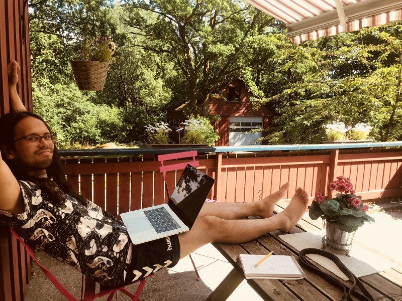 Me on a sunny balcony with a laptop.