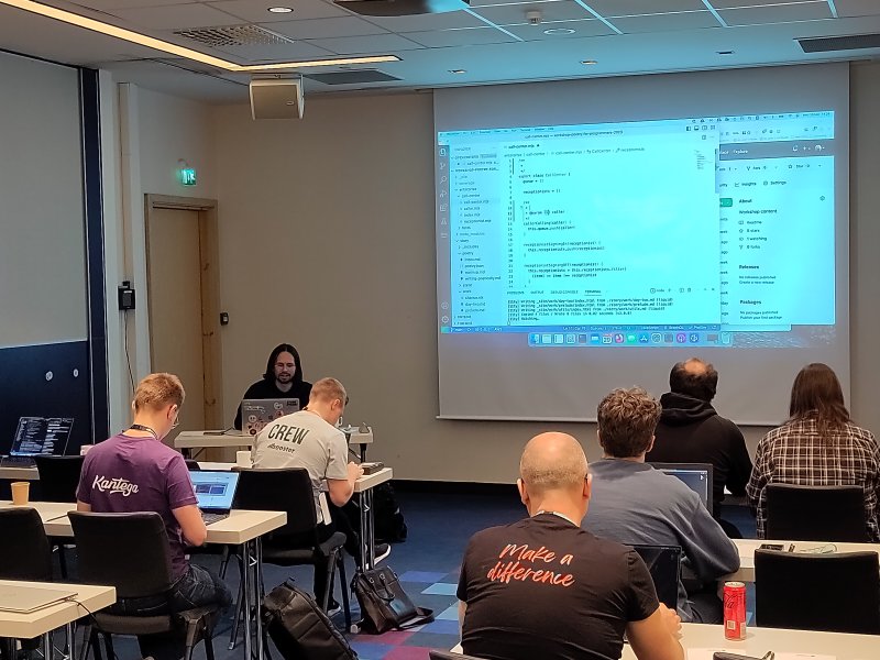 a classroom setting with people behind desks.