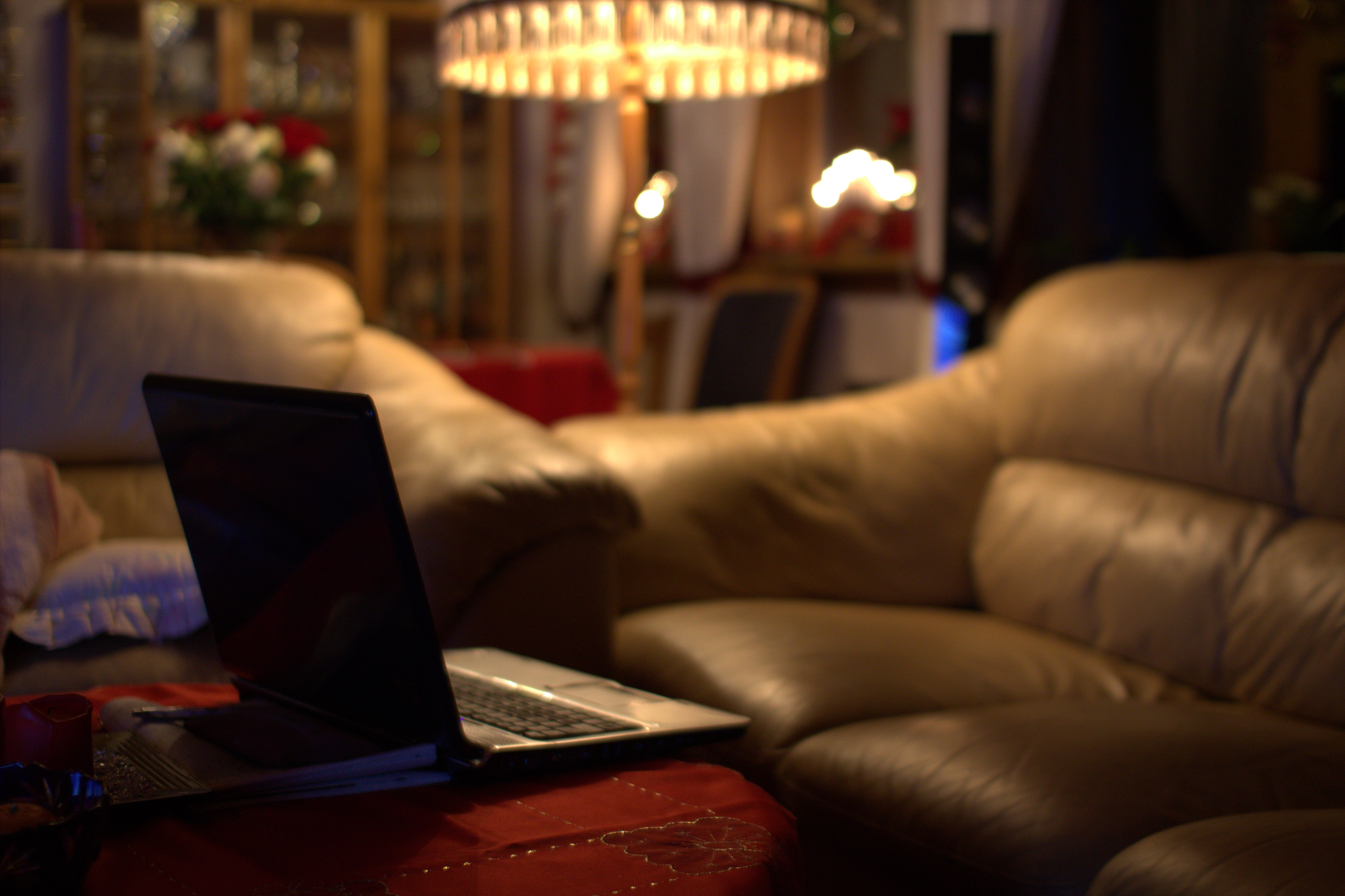 Living room, with an empty sofa and a laptop sitting on a table. 